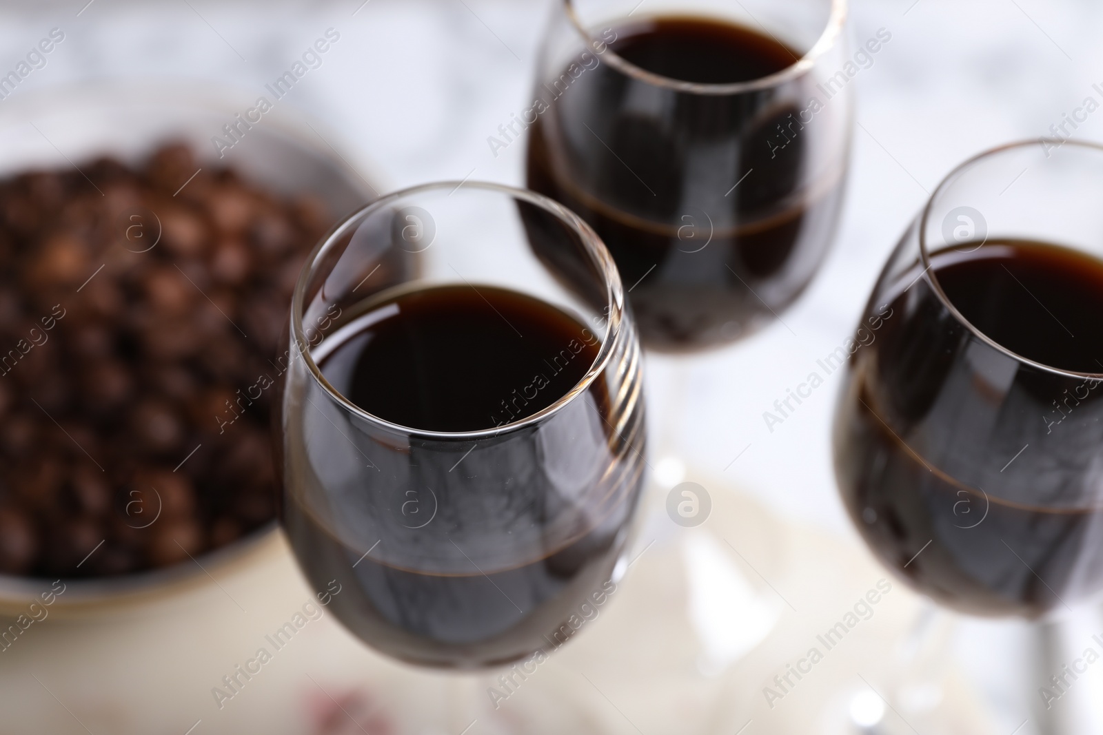 Photo of Glasses of coffee liqueur on blurred background, closeup