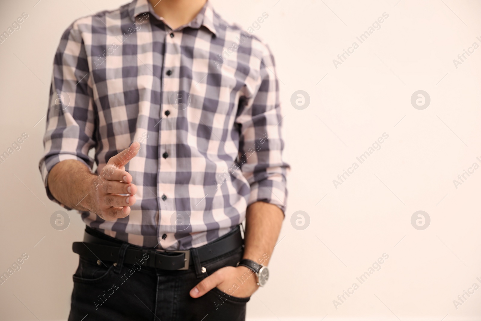 Photo of Man offering handshake on beige background, closeup. Space for text