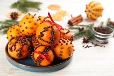 Pomander balls made of fresh tangerines and cloves on white table, space for text