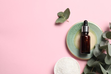 Aromatherapy products. Bottle of essential oil, sea salt and eucalyptus leaves on pink background, flat lay. Space for text