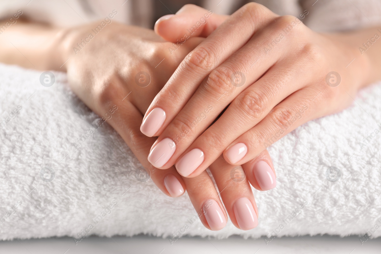 Photo of Closeup view of beautiful female hands on towel. Spa treatment