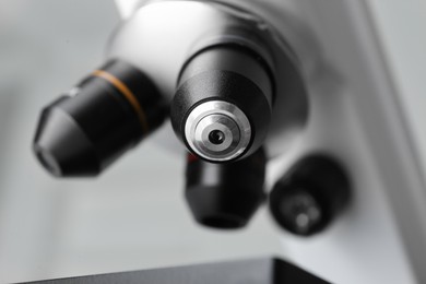 Closeup view of modern medical microscope on grey background