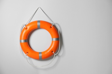 Photo of Orange lifebuoy on light background. Space for text