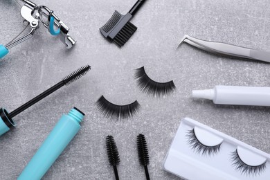 Flat lay composition with false eyelashes and tools on light grey background
