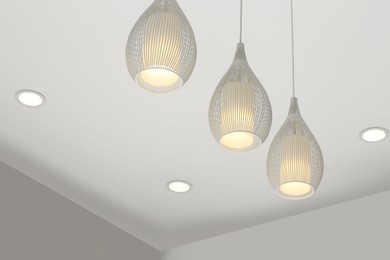 Photo of White modern lighting on ceiling in room, low angle view