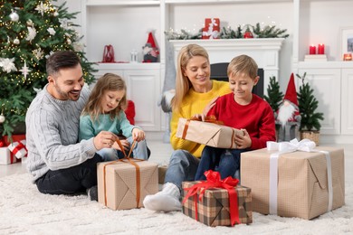 Photo of Parents and their children opening Christmas gifts at home