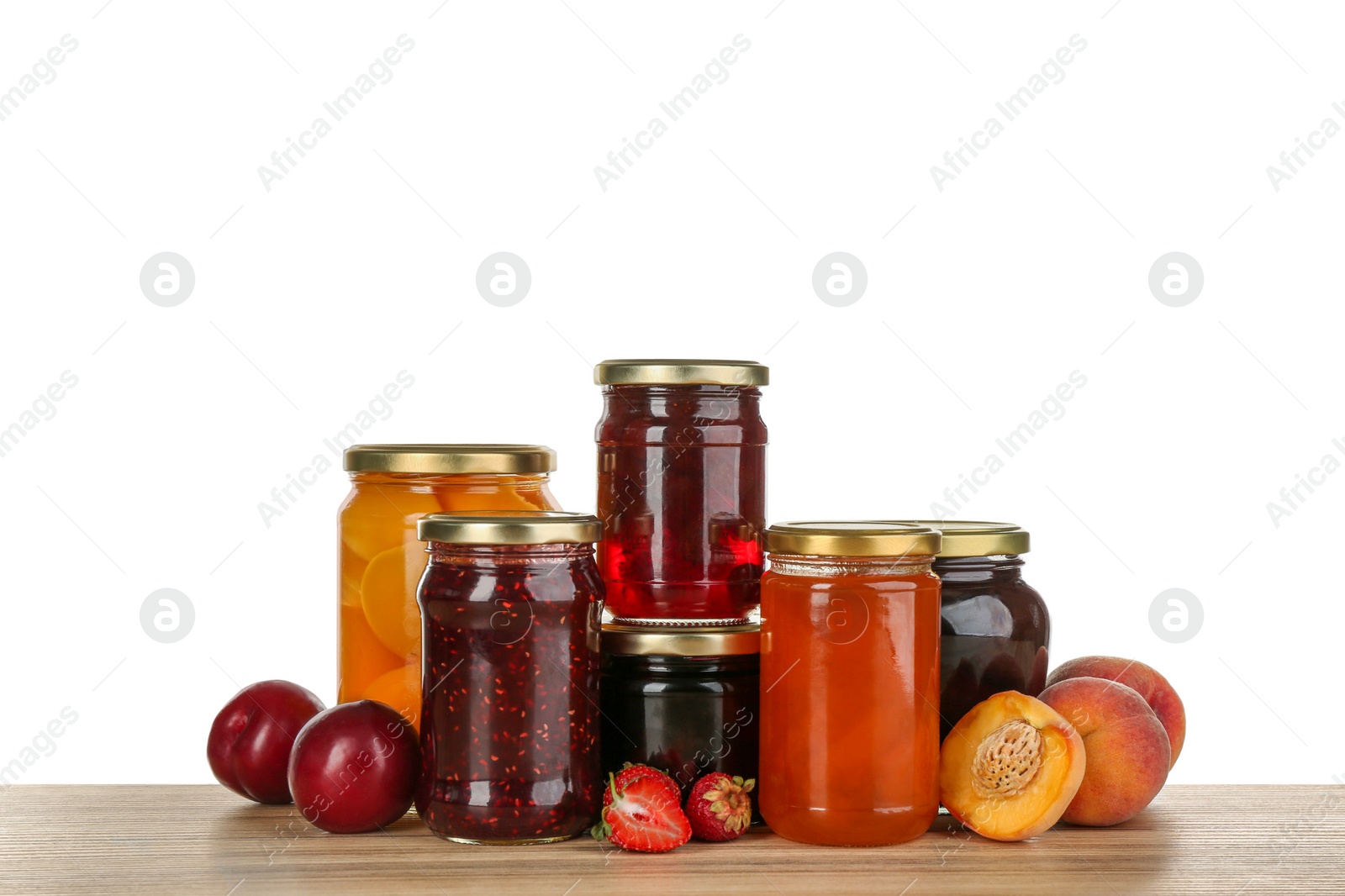 Photo of Jars of pickled fruits and jams on wooden table