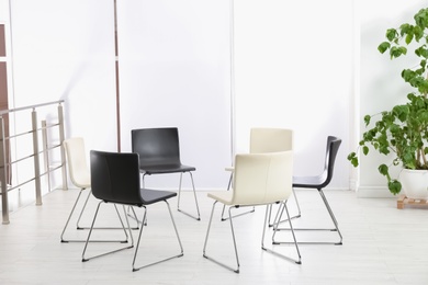 Photo of Empty chairs prepared for group psychotherapy session indoors