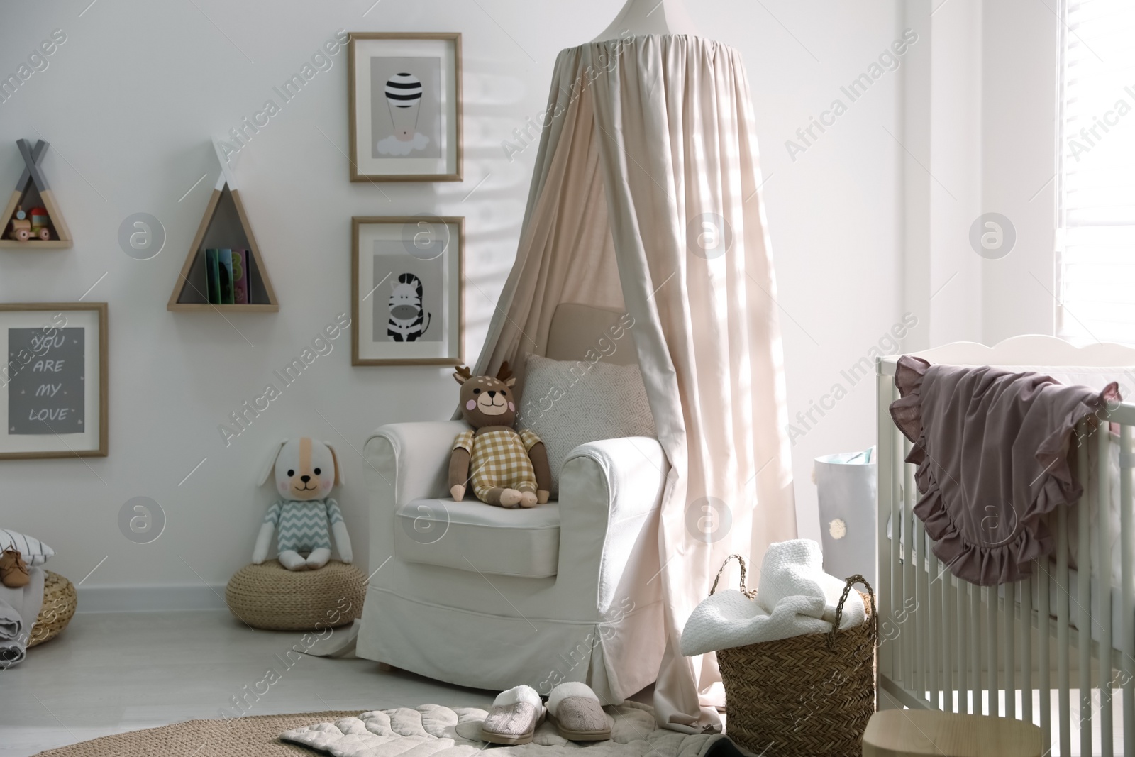 Photo of Stylish baby room interior with crib and comfortable armchair