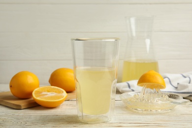 Photo of Freshly squeezed lemon juice on white wooden table