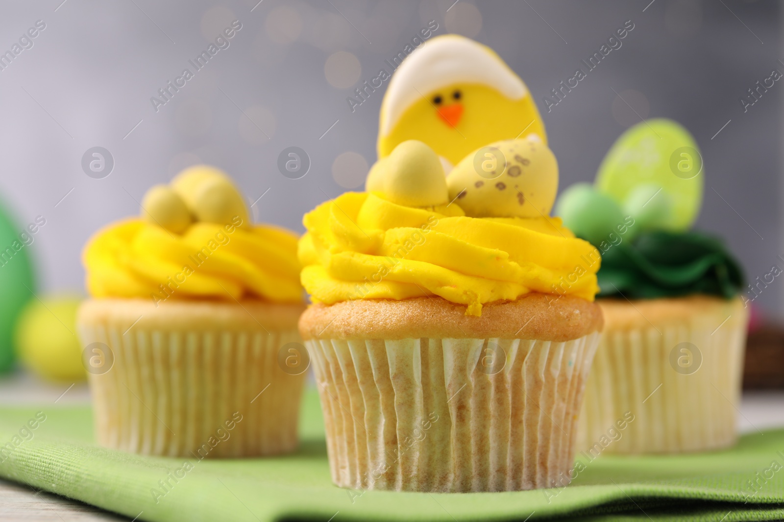 Photo of Tasty cupcakes with Easter decor on table, closeup