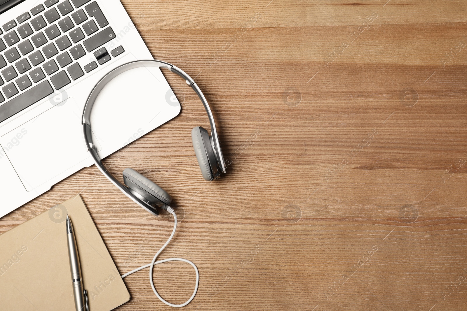 Photo of Flat lay composition with headphones, laptop and space for text on wooden background