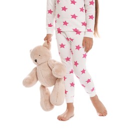 Photo of Cute girl wearing pajamas with teddy bear on white background