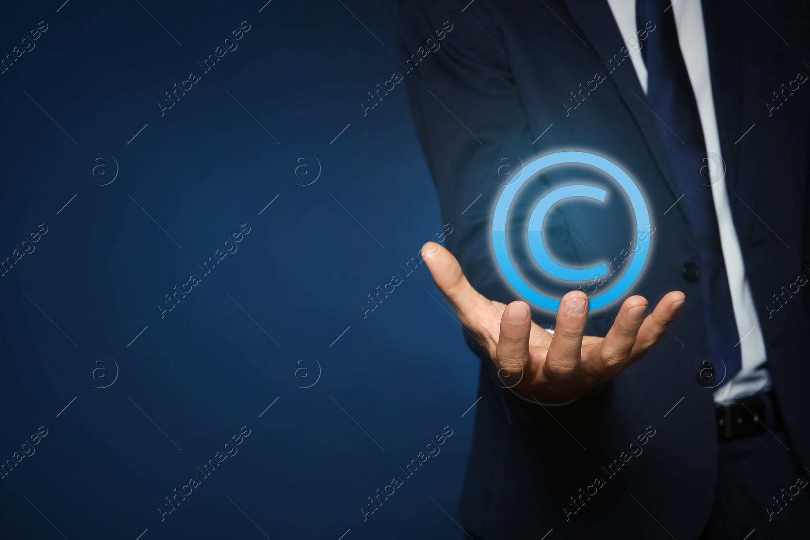 Image of Man holding virtual icon of copyright symbol on blue background, closeup. Space for text