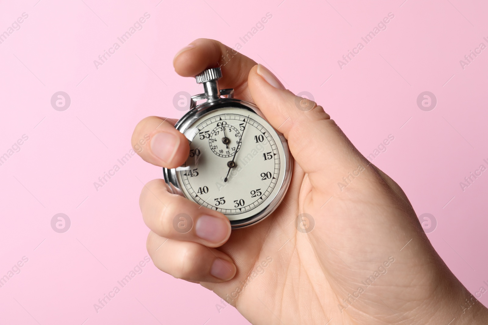 Photo of Woman holding vintage timer on pink background, closeup