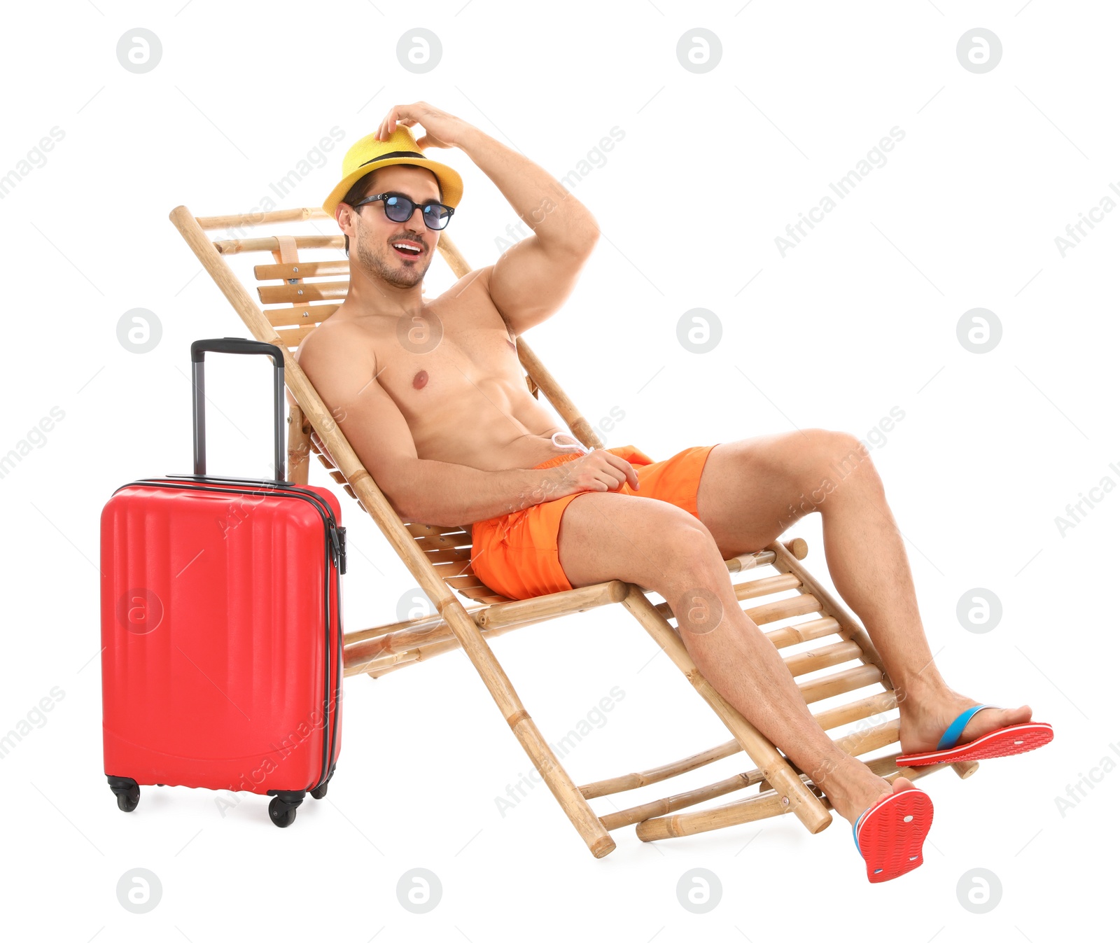 Photo of Young man with suitcase on sun lounger against white background. Beach accessories