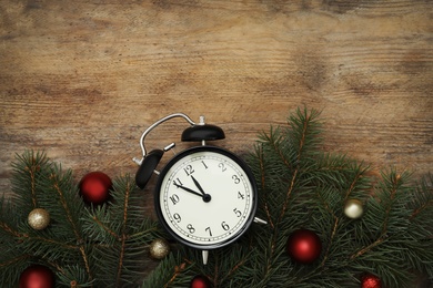 Photo of Alarm clock and Christmas decor on wooden background, flat lay with space for text. New Year countdown