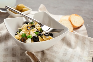 Photo of Tasty pasta salad with black olives on table