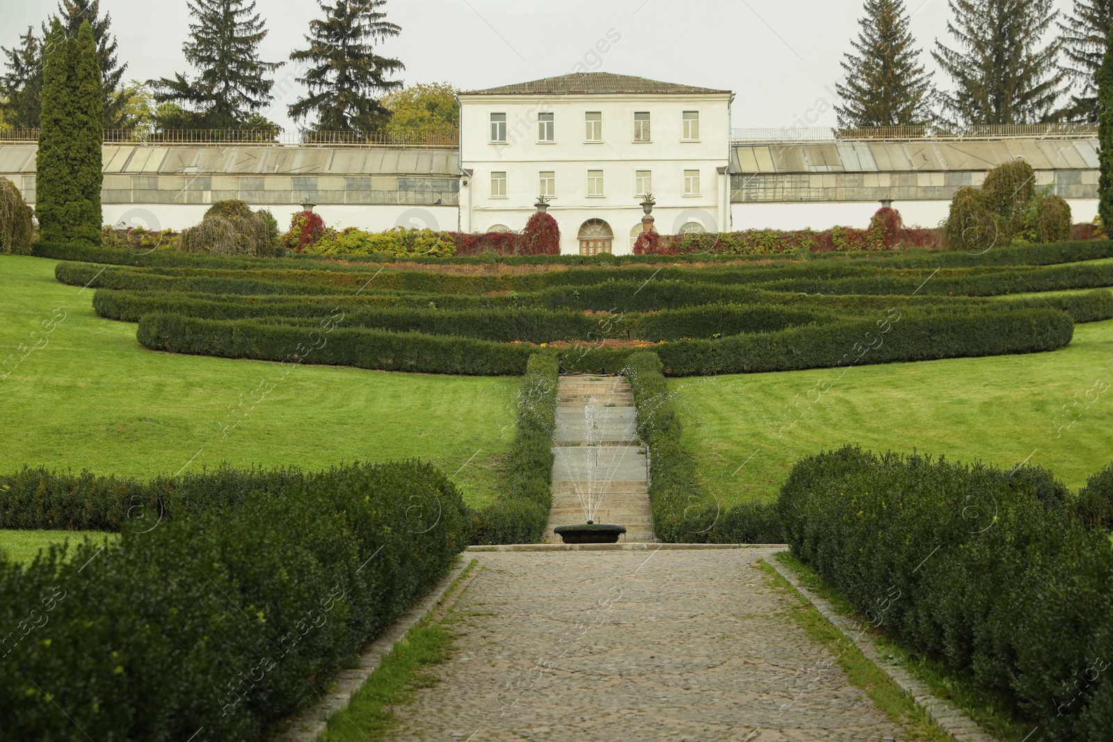 Photo of Beautiful view of park with bushes and building on autumn day