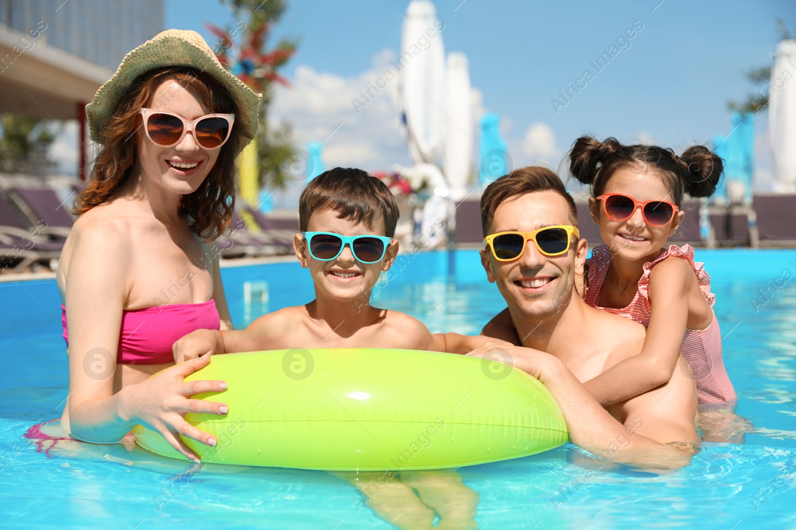 Photo of Happy family in swimming pool at resort