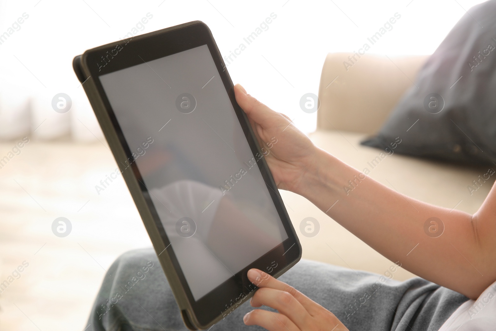 Photo of Woman working with modern tablet indoors, closeup. Space for design