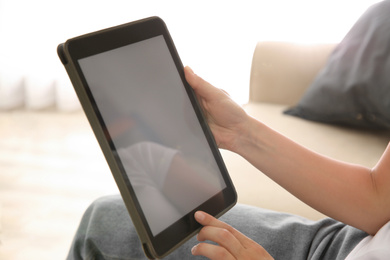 Woman working with modern tablet indoors, closeup. Space for design