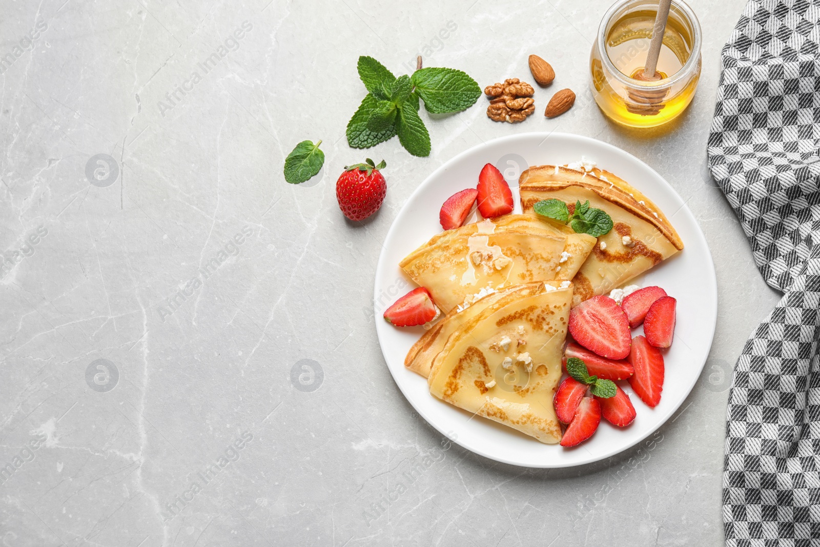 Photo of Delicious thin pancakes with strawberries, cottage cheese and honey on light table, flat lay. Space for text