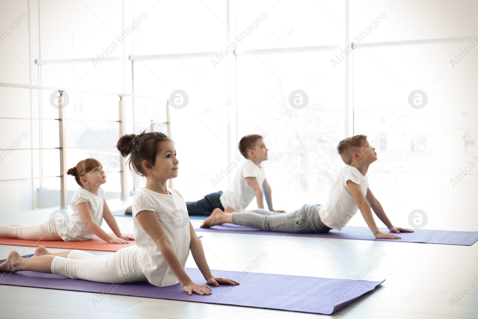 Photo of Little children practicing yoga in gym