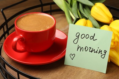 Photo of Beautiful yellow tulips, cup of aromatic coffee and Good Morning note on wooden tray