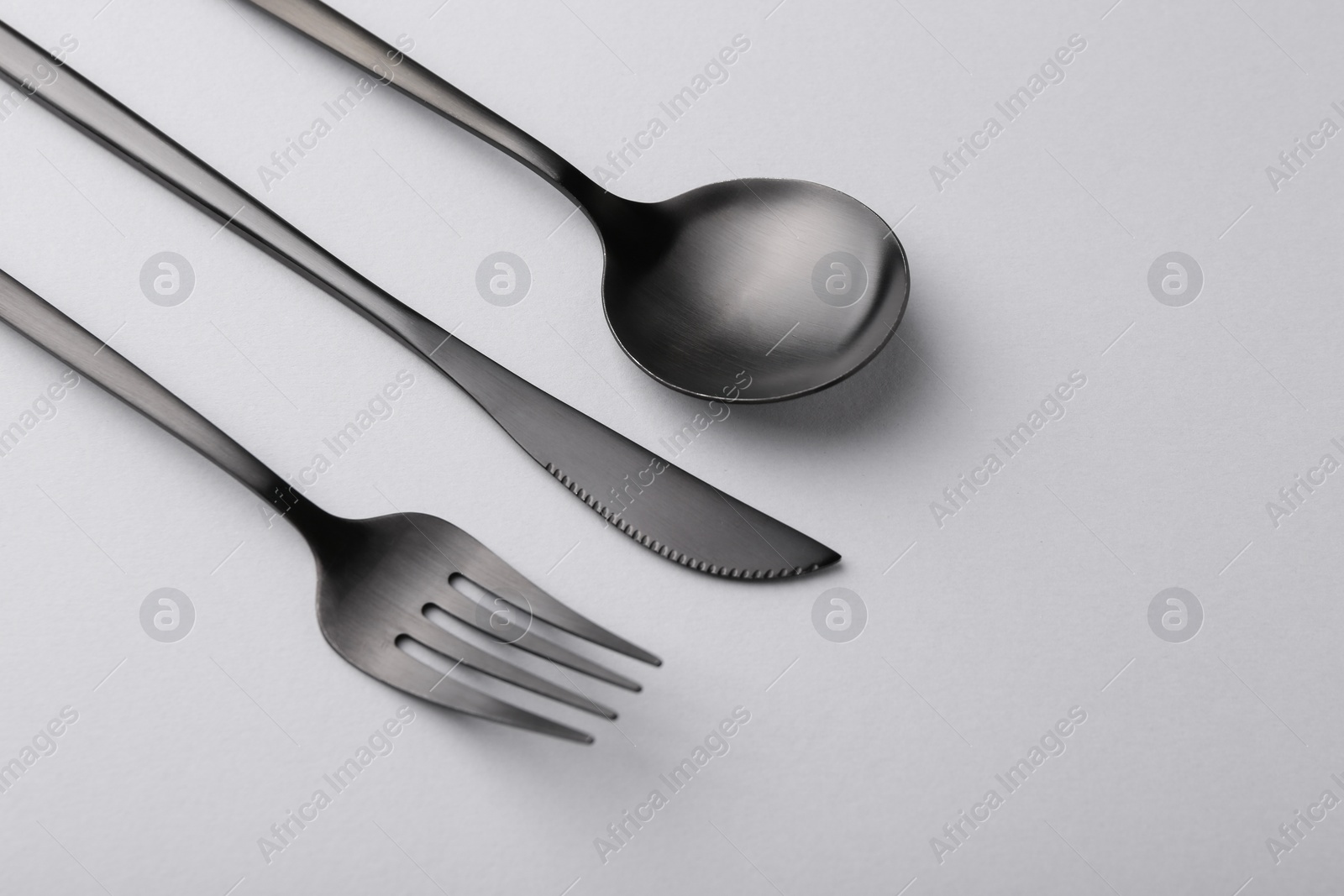 Photo of Stylish cutlery set on grey table, above view. Space for text