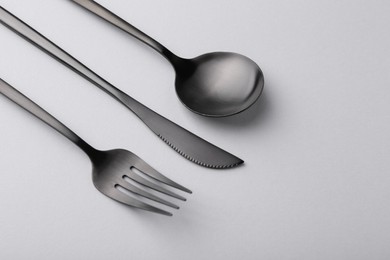 Stylish cutlery set on grey table, above view. Space for text