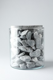 Photo of Presentation for product. Glass container with stones on light grey background