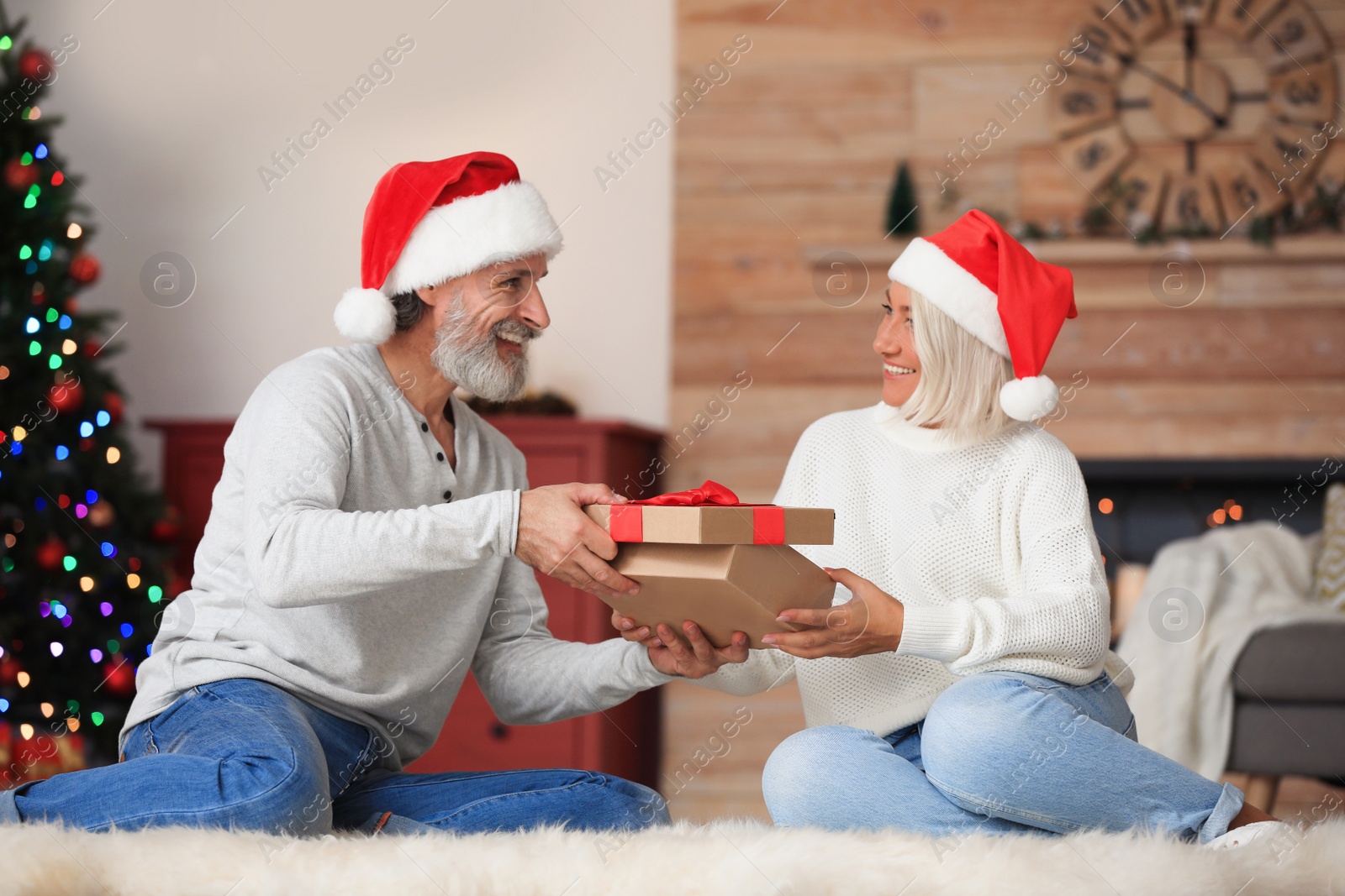 Photo of Happy couple opening Christmas gift at home