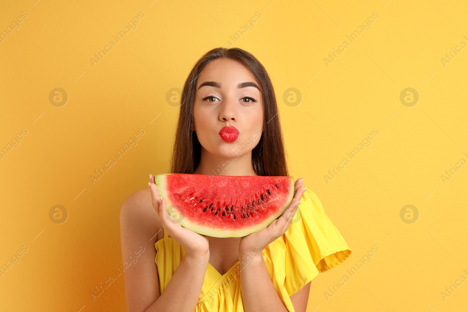 Photo of Beautiful young woman posing with watermelon on color background