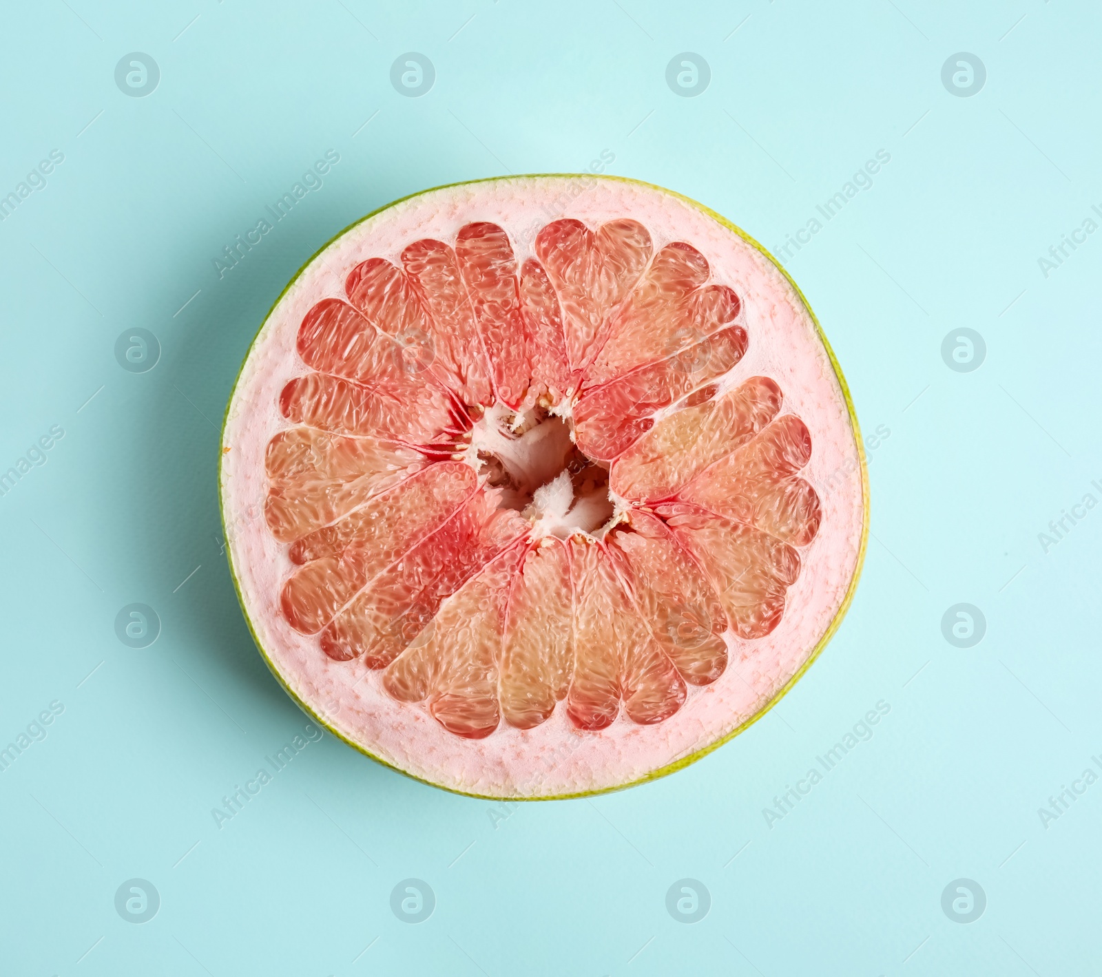 Photo of Fresh cut pomelo fruit on light blue background, top view