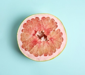 Photo of Fresh cut pomelo fruit on light blue background, top view