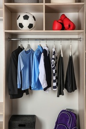 Photo of Wardrobe with stylish boy's clothes hanging on rack