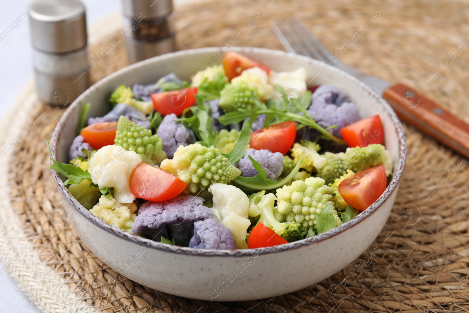 Photo of Delicious salad with cauliflower and tomato served on table, closeup