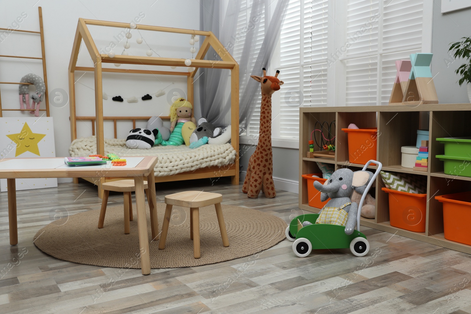 Photo of Cute child's room interior with toys and wooden furniture