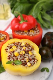 Photo of Quinoa stuffed bell peppers and basil on white table, closeup