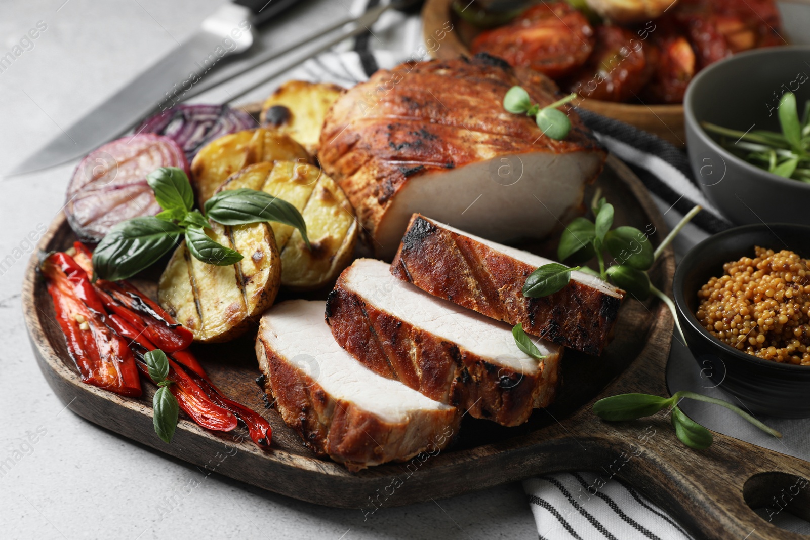 Photo of Delicious grilled meat and vegetables served on light grey table, closeup