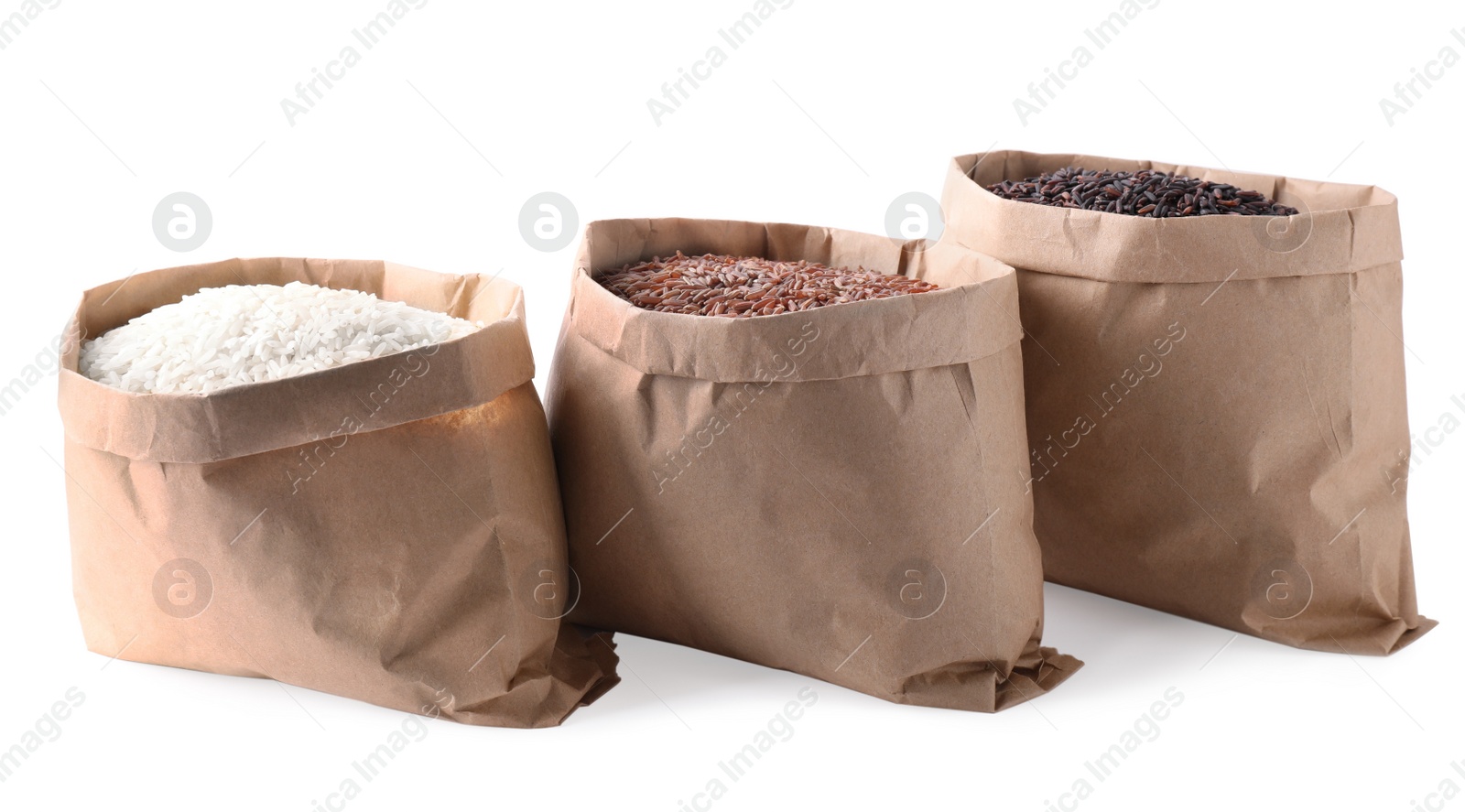 Photo of Brown and polished rice in paper bags on white background