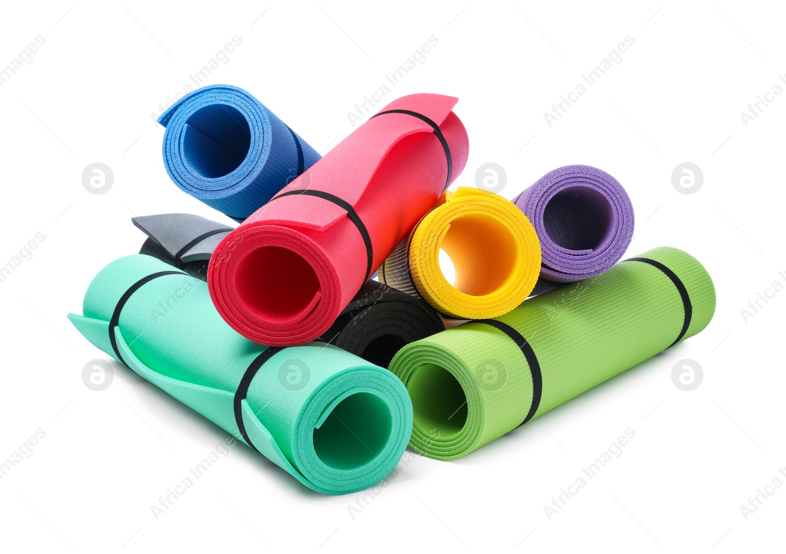 Photo of Colorful rolled camping or exercise mats on white background