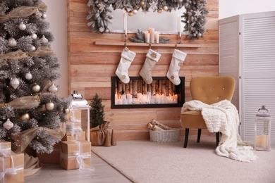 Fireplace with Christmas stockings in room. Festive interior