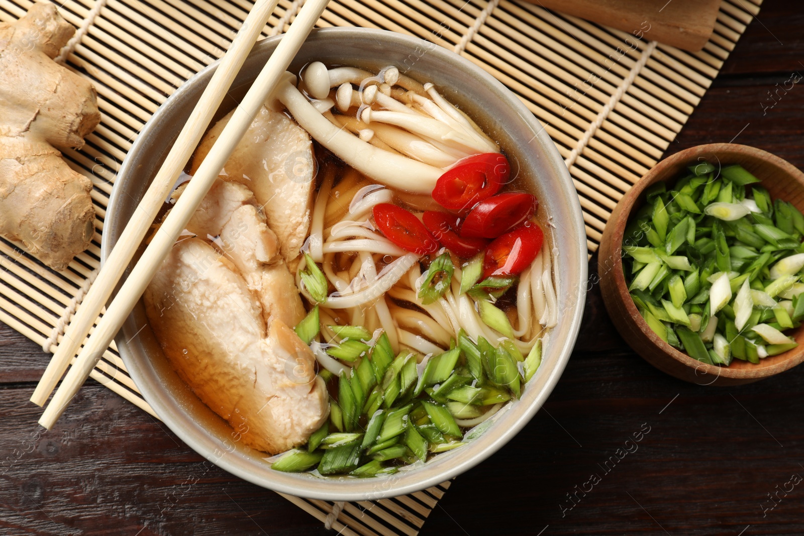 Photo of Delicious ramen with meat and ingredients on wooden table, flat lay. Noodle soup