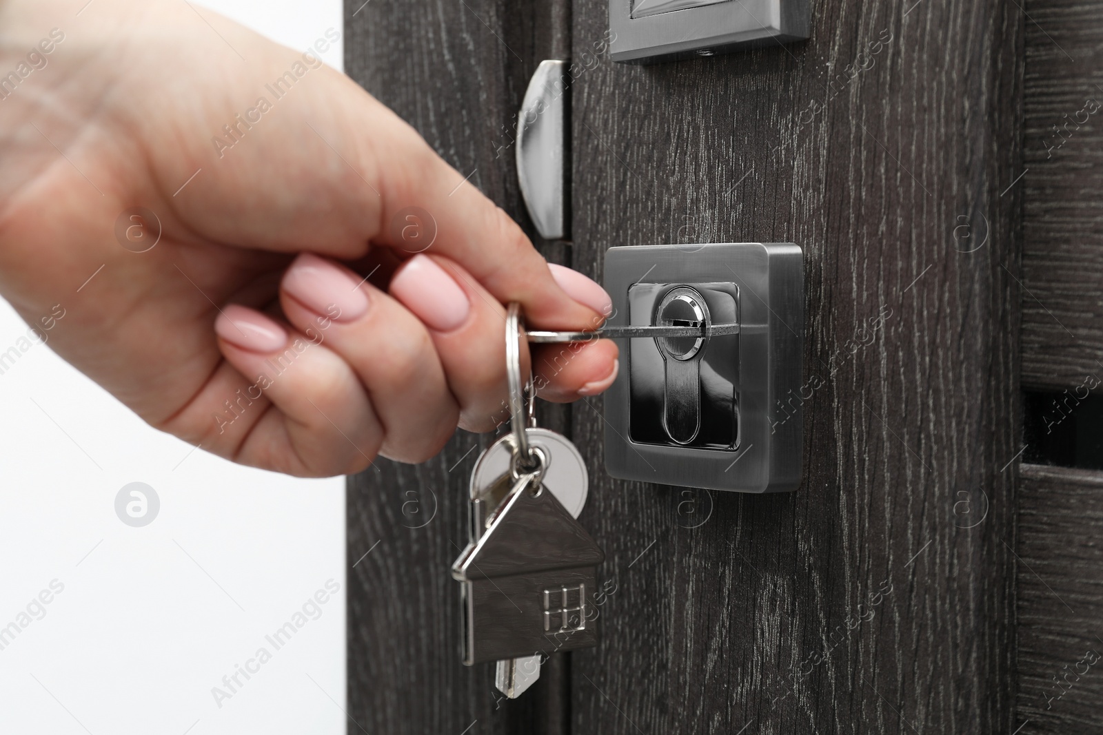 Photo of Woman unlocking door with key, closeup view