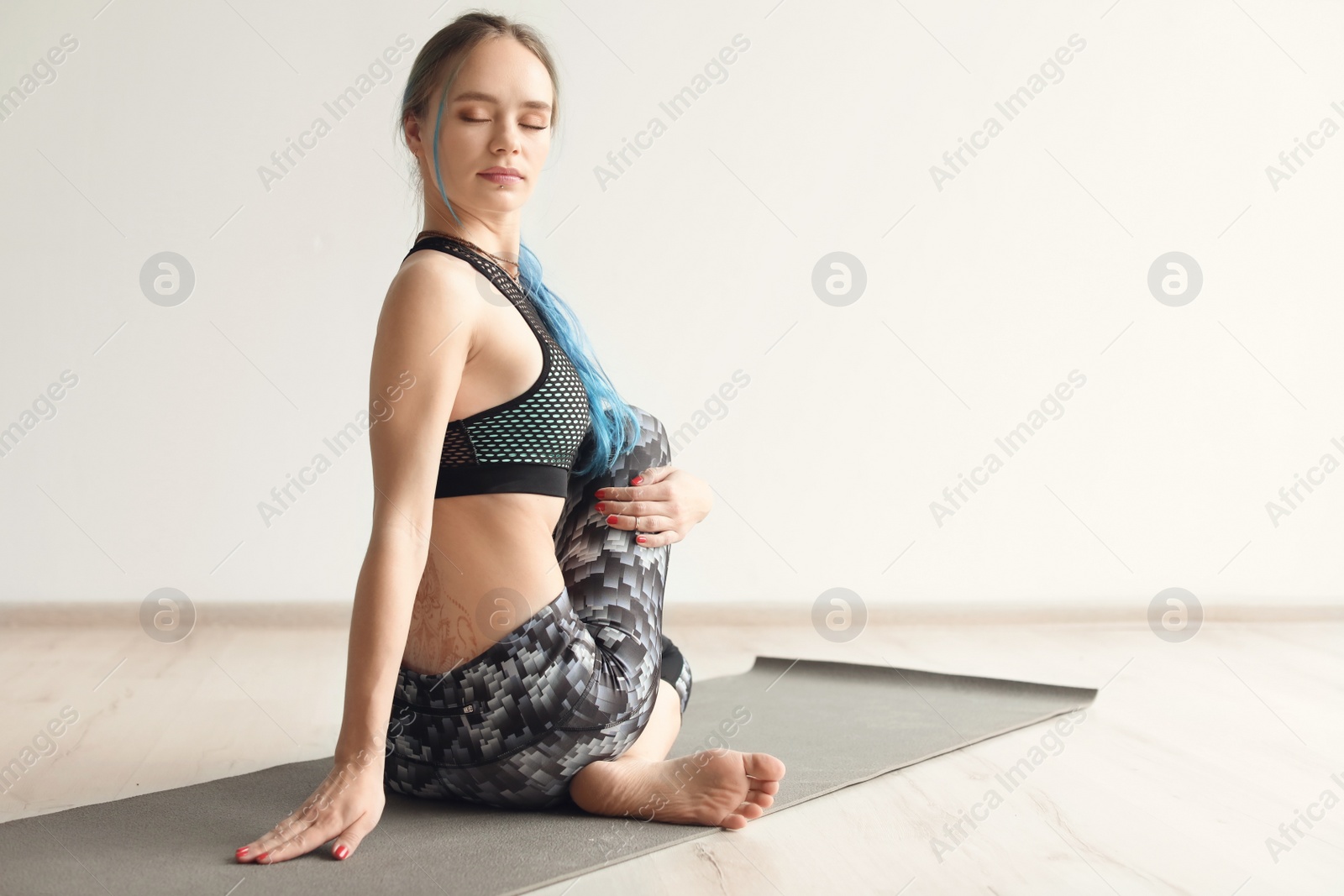 Photo of Young woman practicing yoga indoors