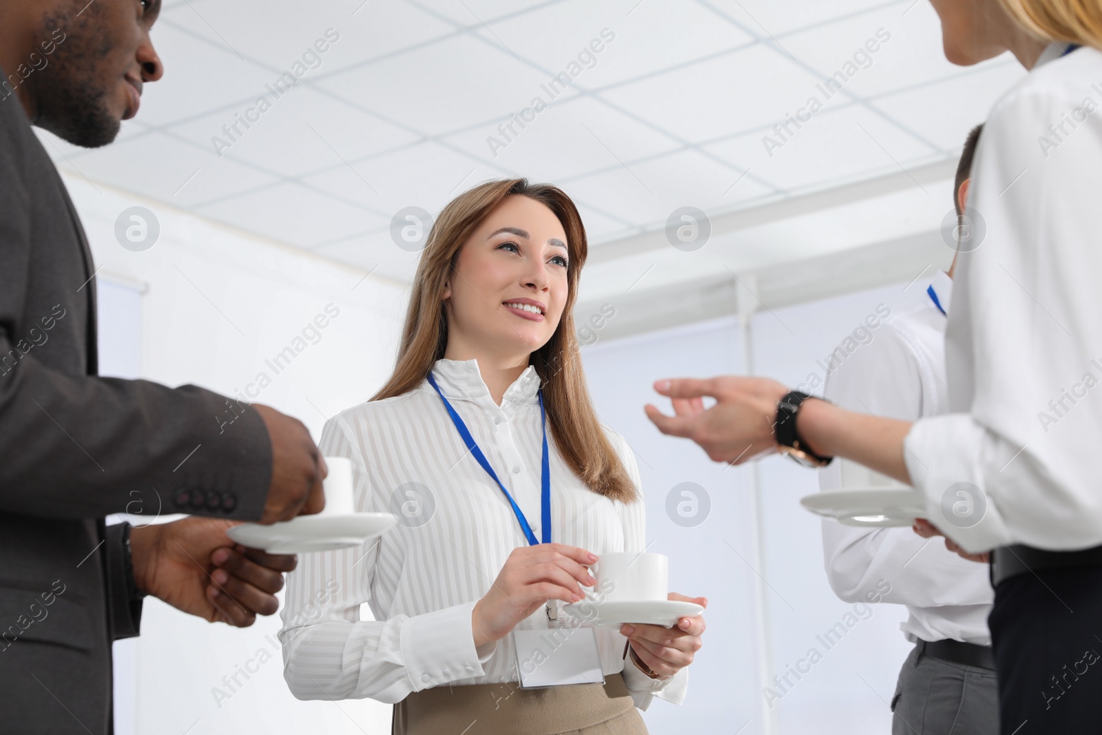 Photo of Group of people chatting during coffee break indoors