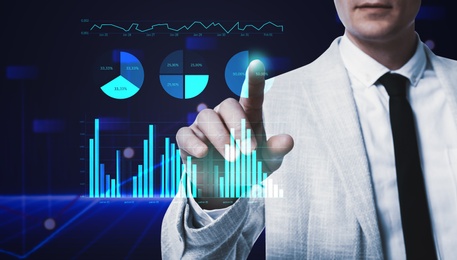 Image of Business analytics. Man and virtual screen with graphs on color background, closeup 