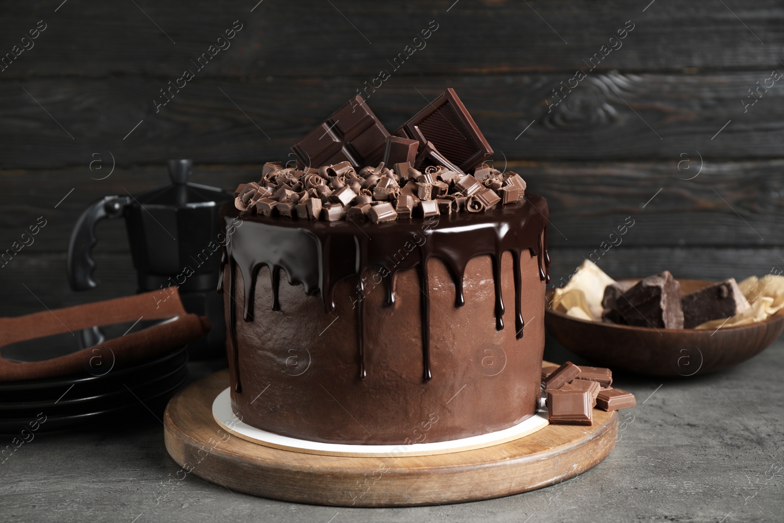 Photo of Freshly made delicious chocolate cake on grey table against black background